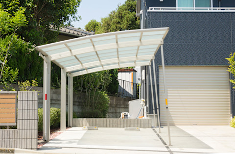 This image shows a car port in the driveway of a residential home.