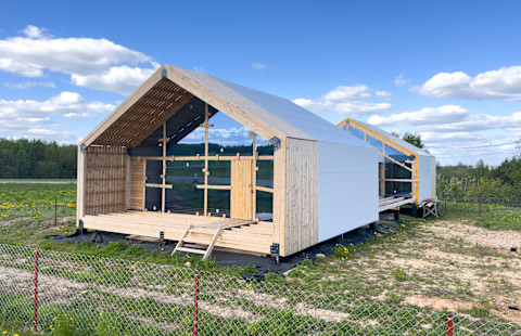 This image shows a newly constructed barndominium building.  The building is made from wood and work is still in progress.