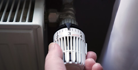 A hand turning on central heating