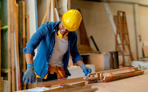 A carpenter is measuring some wood.