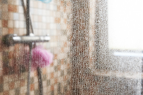 A dirty glass shower door.