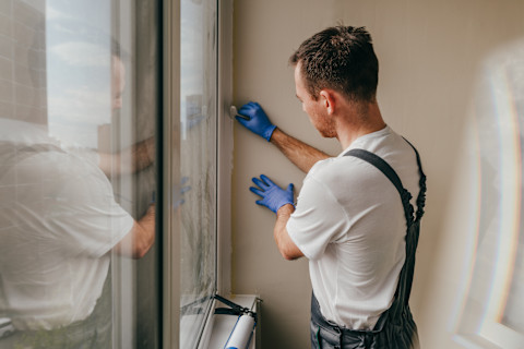 Handyman using tools to remove caulking