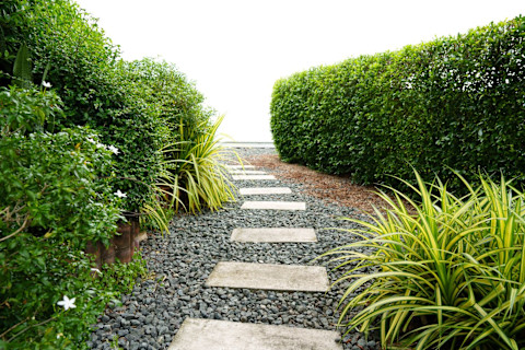 A tile path with pebbles in a garden outside