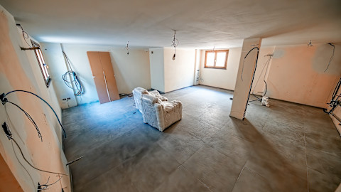 Basement under renovation with exposed wiring and unfinished walls. Home improvement project to finish a basement into a livable space. Basement remodeling costs and professional renovation work.