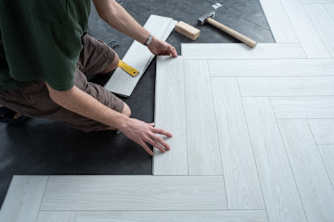 A pro is installing a new laminate wooden floor.