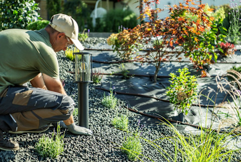 A landscaper working on the ground of a garden.