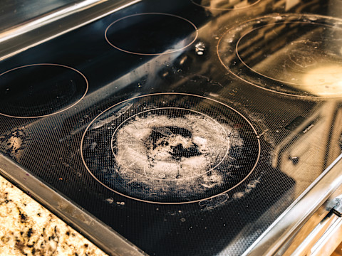 A dirty and damaged glass stove top