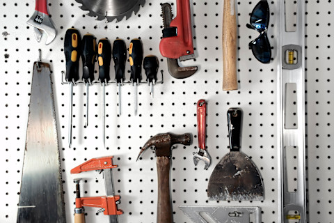  Tools hanging neatly on a board in a garage.