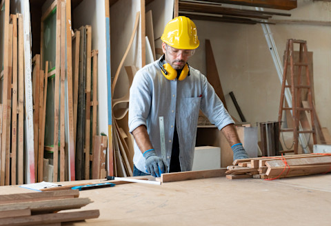 A carpenter is measuring some wood.
