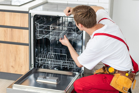 worker installing a dishwasher 