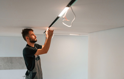 A man is checking a new lighting system.