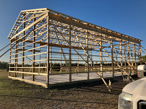 A wooden pole barn structure outside