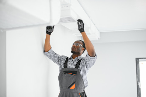worker fixing the heating cooling system
