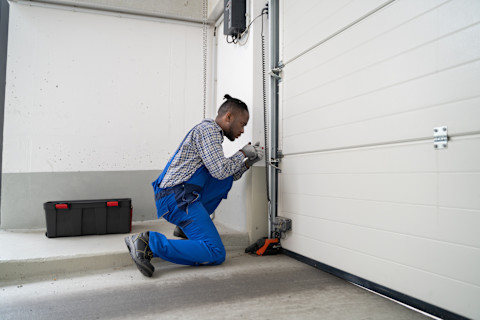 A man is installing a new garage door.
