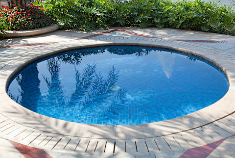 A round inground swimming pool in garden