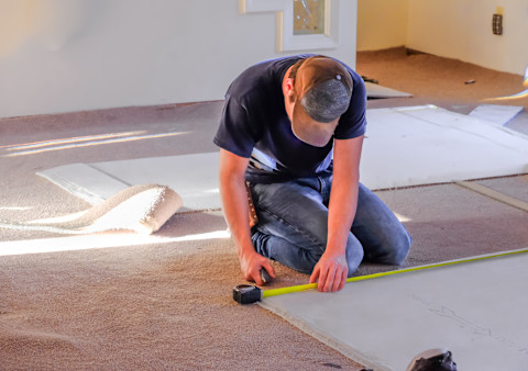 worker installing carpet