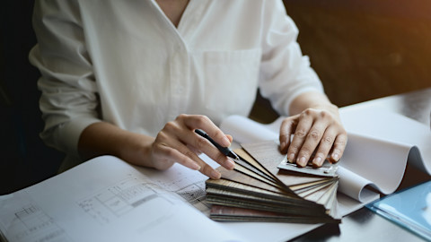 An interior designer is looking through her plans.
