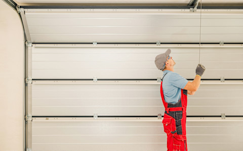 A man is busy fitting a new garage door.