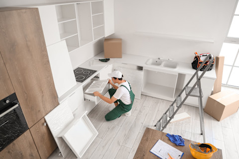 A professional is busy fitting a new kitchen.