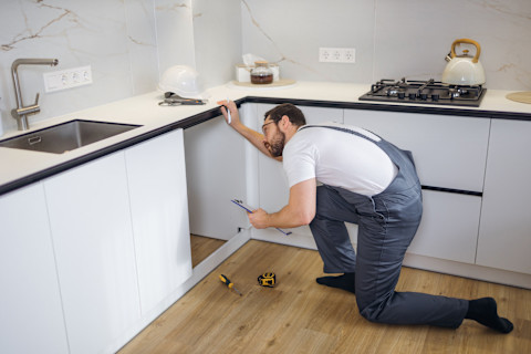 A professional is busy fitting a new kitchen.